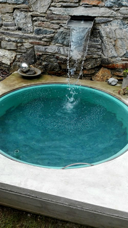 fließendes Wasser aus Steinmauer,
Wasserbecken